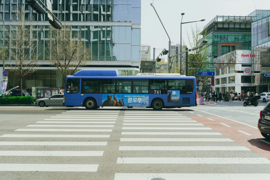 Vibrant cityscape of a blue bus and modern architecture in downtown Seoul, South Korea.